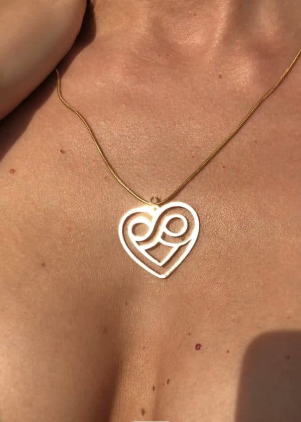 Gold heart infinity pendant necklace on skin